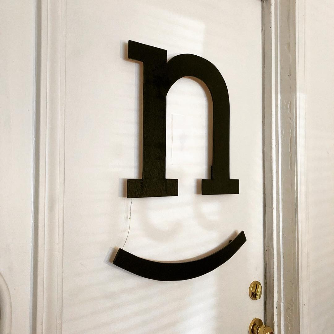 Black wooden logo attached to the door.