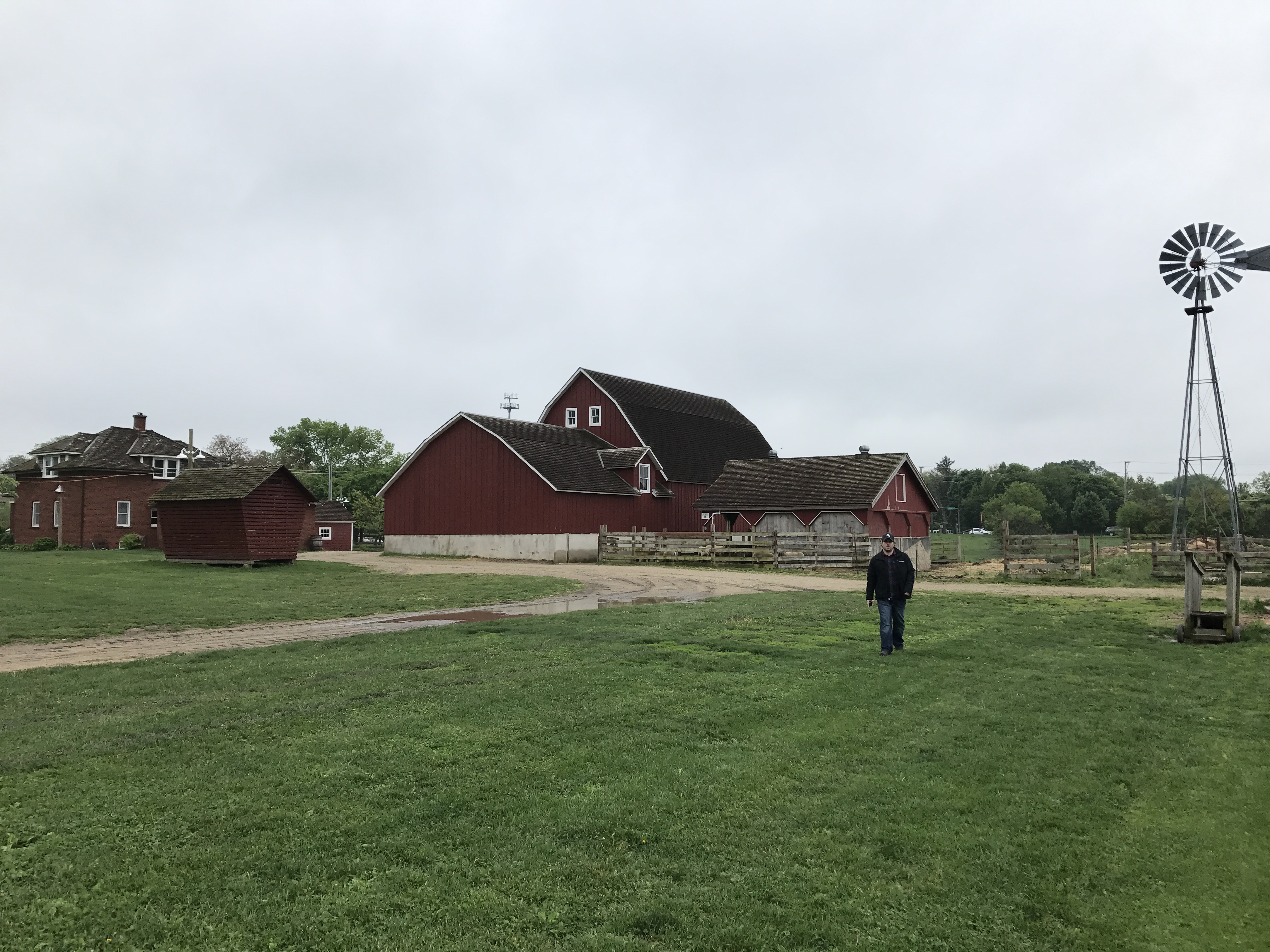 Nick Volkert walking in front of the windmill, barn and farm house at Historic Wagner Farm in Glenview, IL.