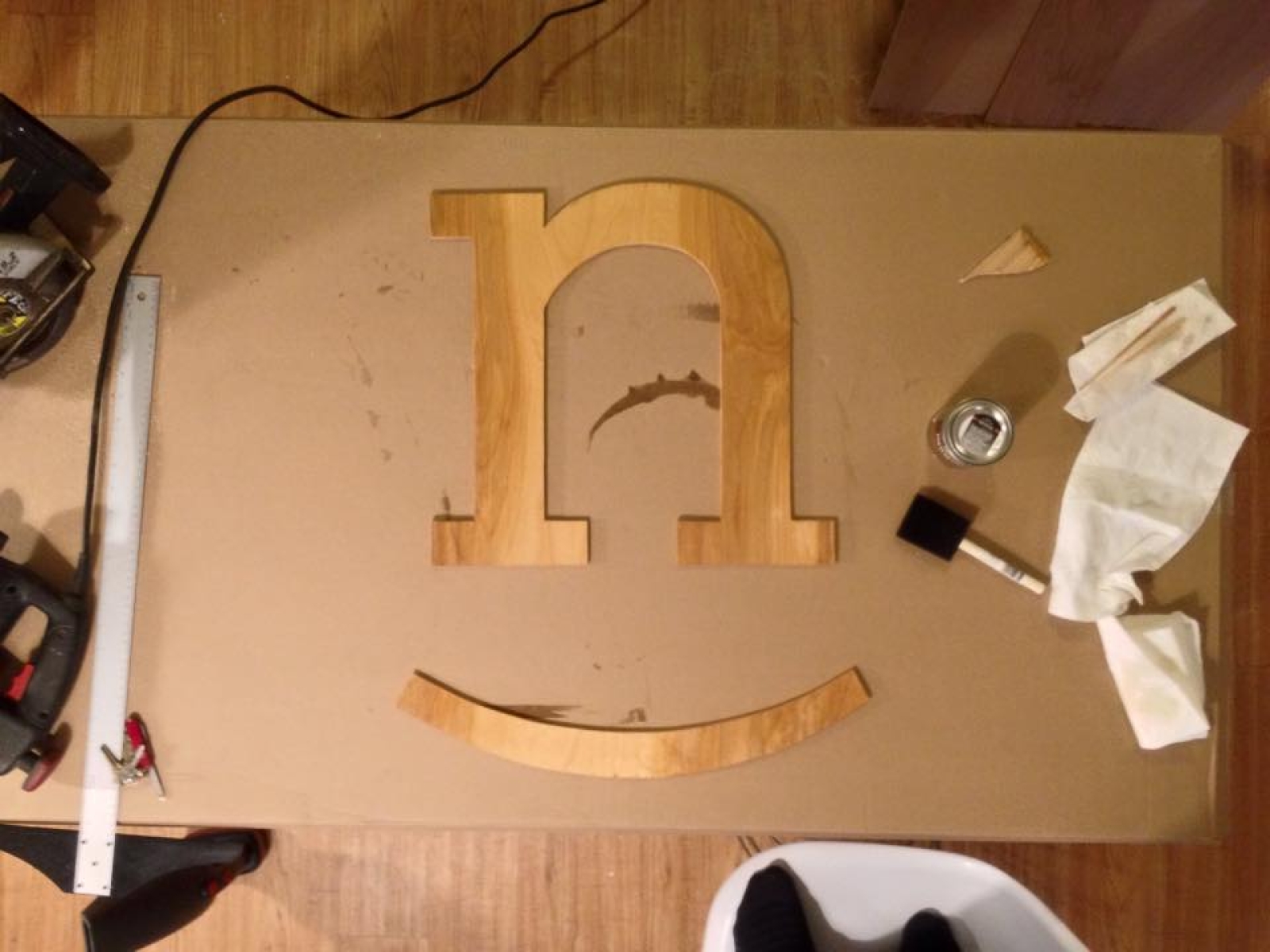 Cut from a paper stencil, the Nicer wooden mark was stained before being illuminated and hung in Nicer Collaborative's studio. Wood-cut Nicer Collaborative mark.