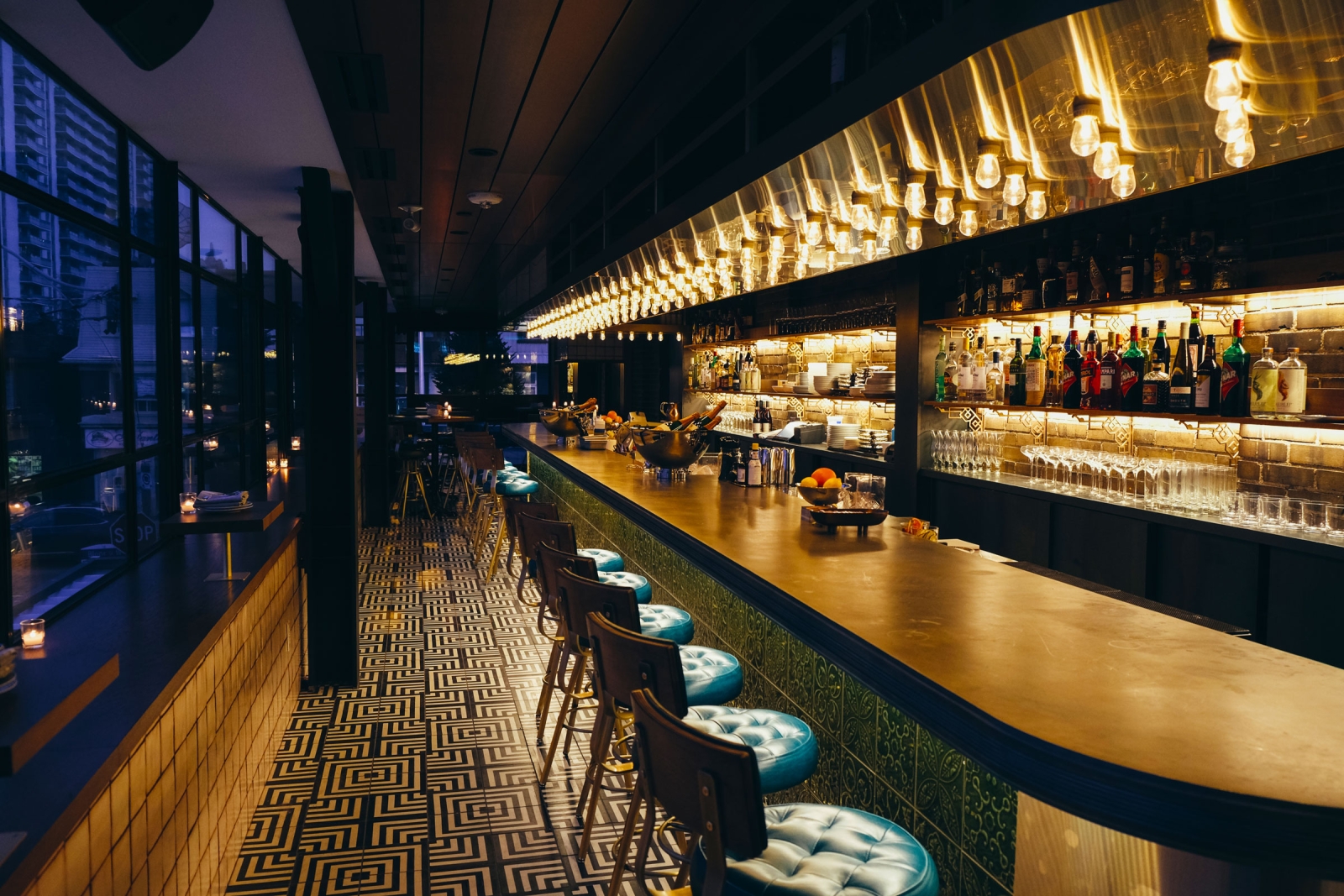 View through bar biltmore in the evening with blue tufted bar stool seats