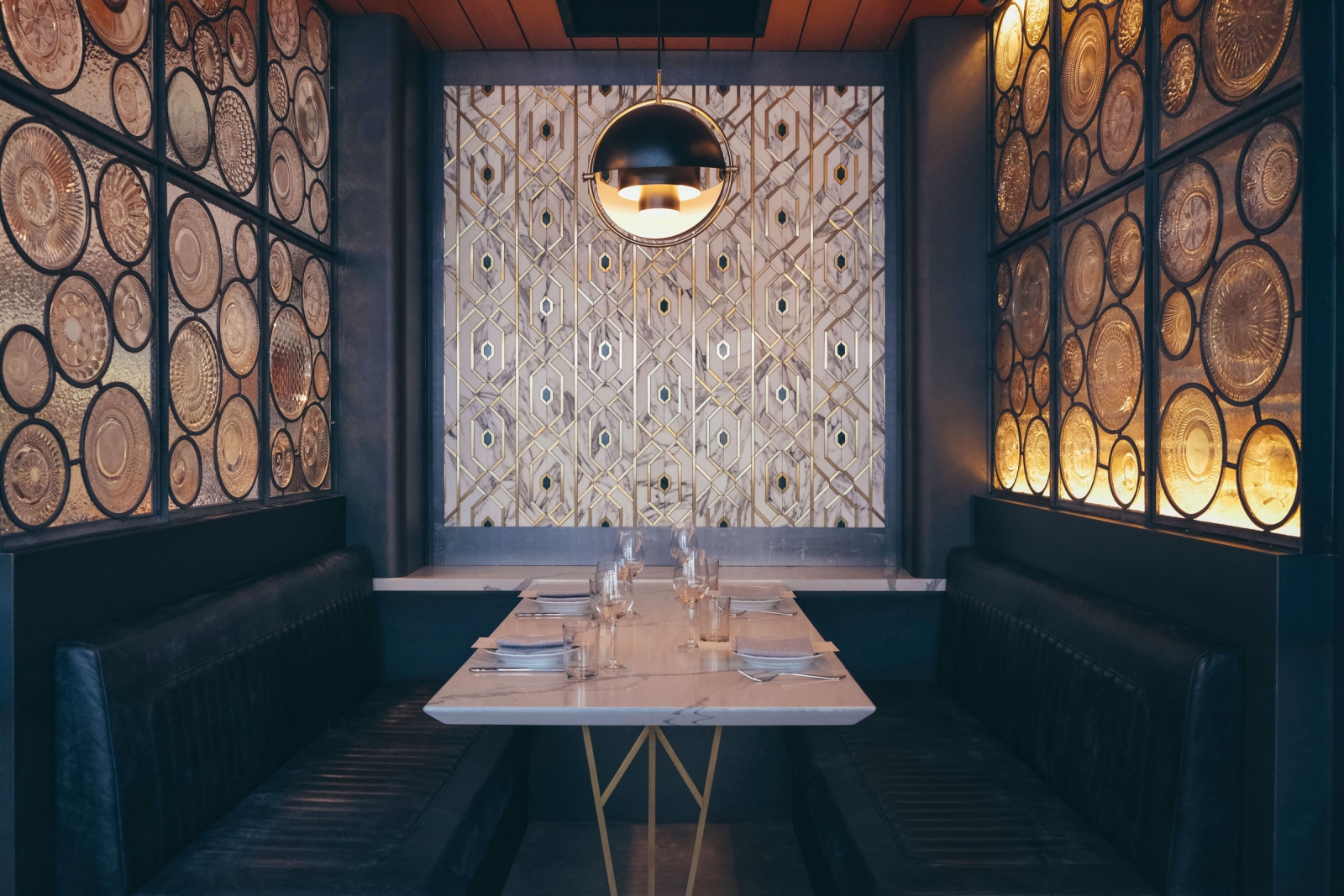 Osteria Rialto booth with fancy light fixture and artistic glass panels