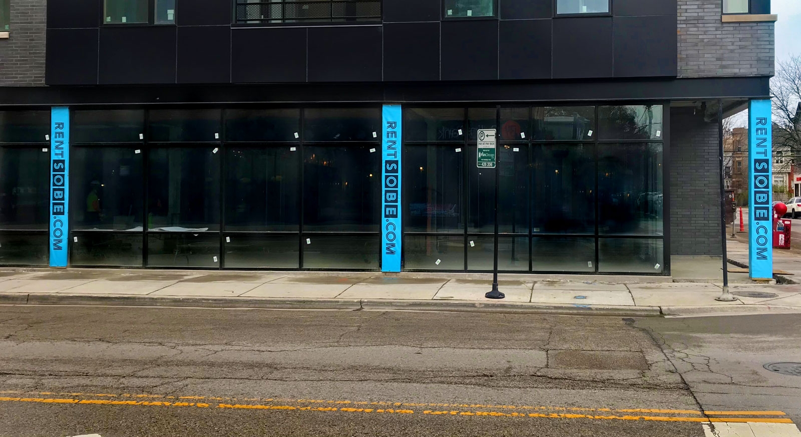 Banners affixed to building columns located along Belmont Avenue that read RENTSOBE.COM.