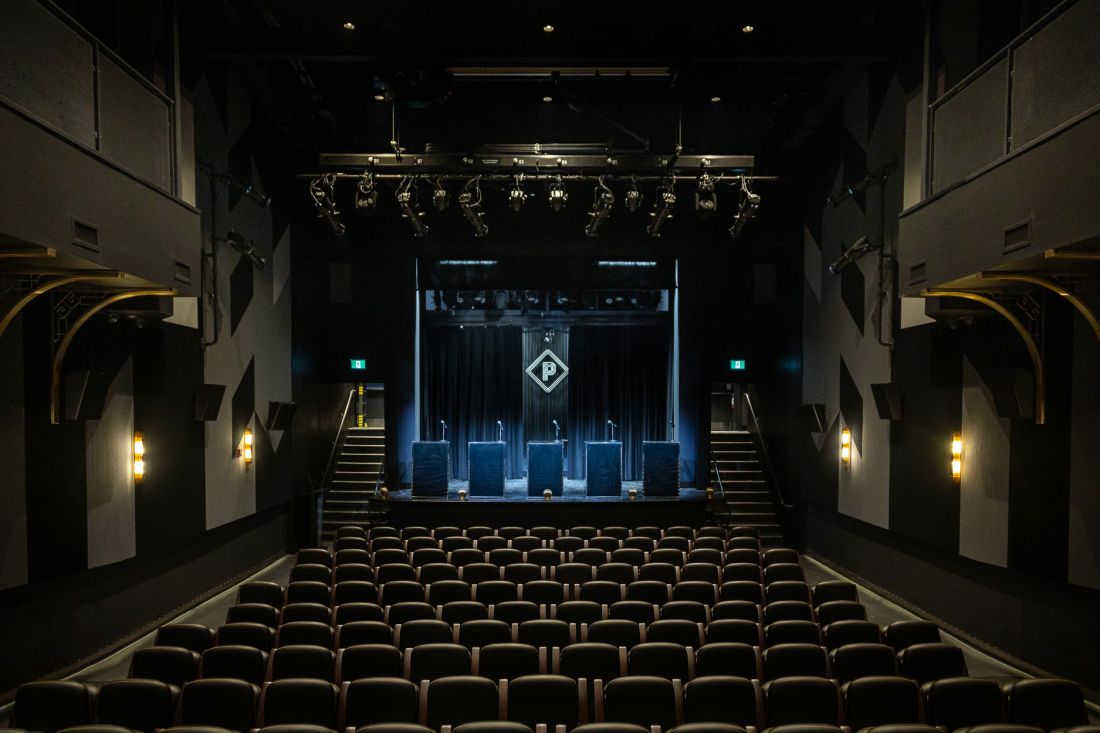 View inside the theatre looking over seats to the stage with an illuminated Paradise Theatre logo